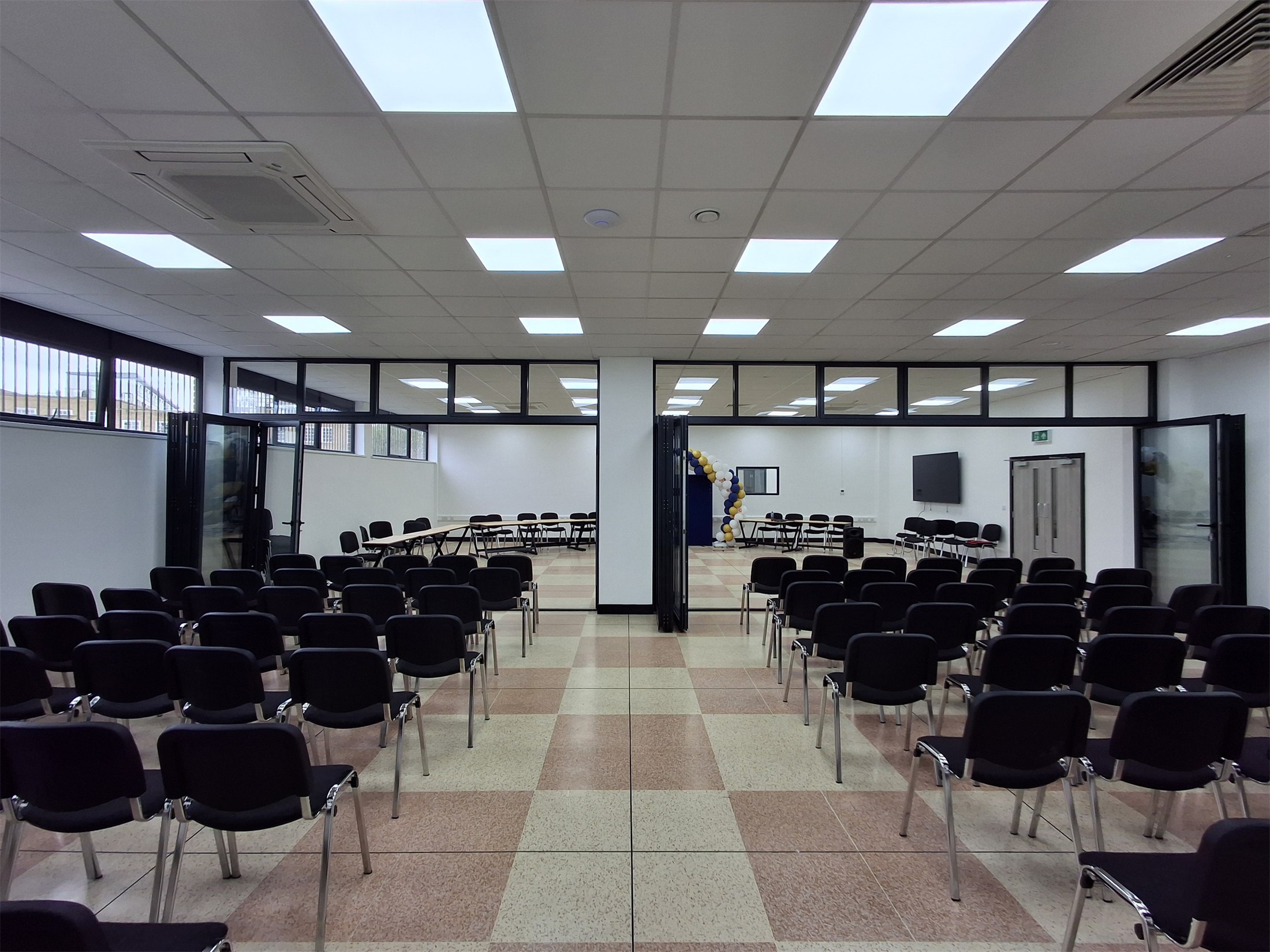 A prepared event room with rows of chairs and a balloon arch